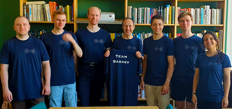 Group of researchers pose for photo with "team Babaev" t-shirts