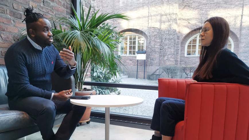 Mentor Jerry Onyeche and student Marina Brandt discussing in the entrance hall to KTH library. 
