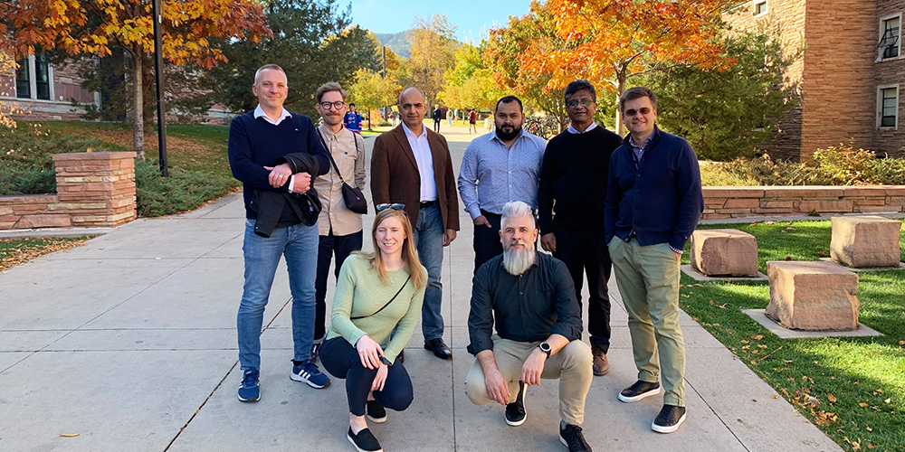 Gruppbild av teamen i Boulder, utomhus med gula löv i bakgrunden