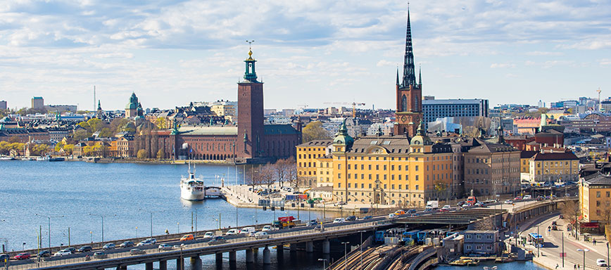 En vy över Stockholms stadshus och trafik.