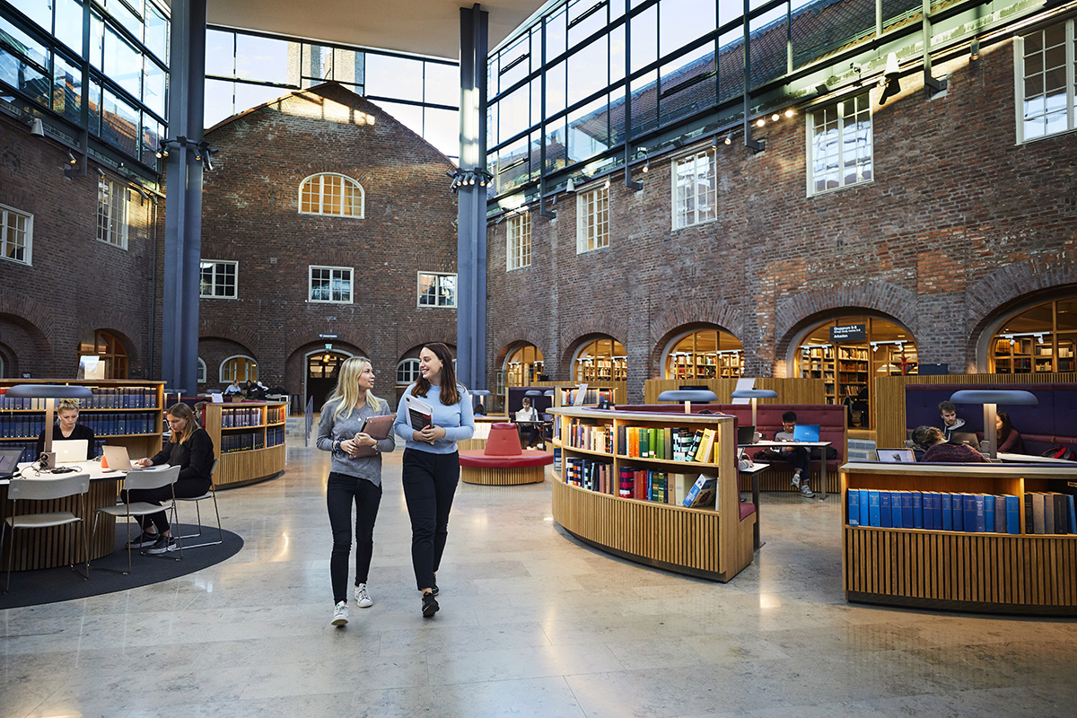 Two young women walks through the main hall at KTH Library
