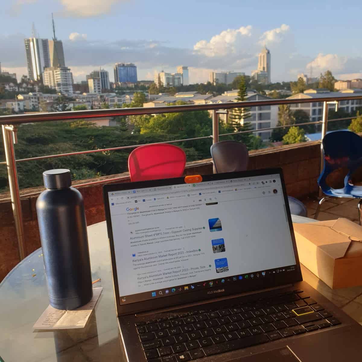 En bild från när jag sitter och pluggar med min laptop på en takterass med utsikt över staden