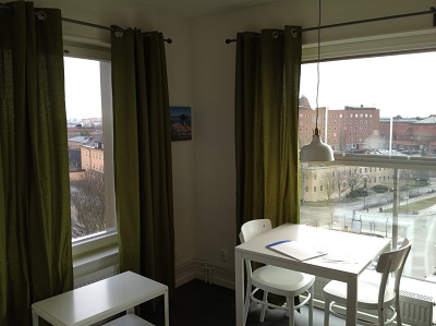 Interior of apartment with two windows, facing different directions.