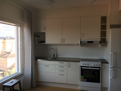 Kitchen next to window in white painted apartment.