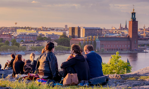 En grupp studenter som sitter på Skinnarviksberget i Stockholm