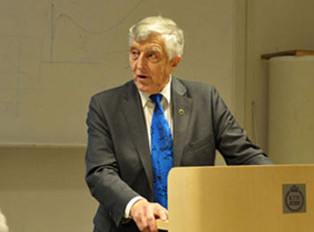 Bild på professor Janne Carlsson som står i en talastol.