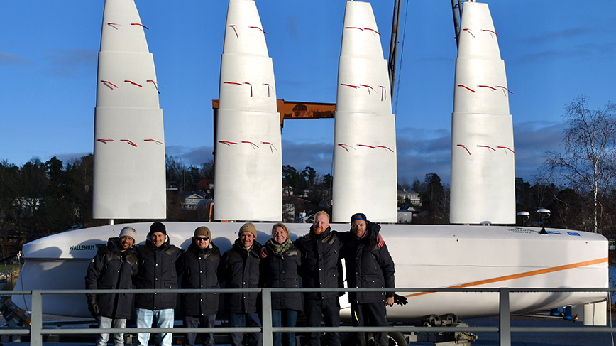 group of students poses with 1:30 scale model of the ocean cargo ship 