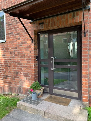 Glass door entrance to red brick building.
