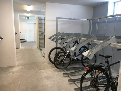 Indoor bike storage with bike racks and small windows.
