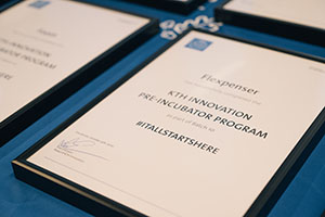 Flexpensers inramade diplom från KTH Innovations förinkuator ligger på en blå duk