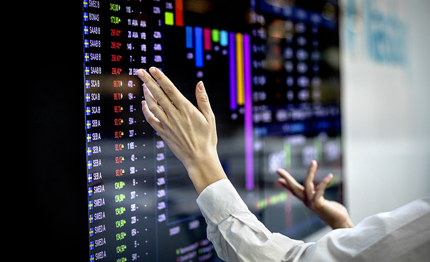 A person checking the stock market prices at Nasdaq Stockholm.