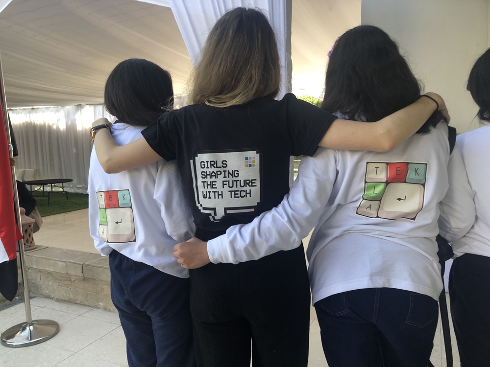  Three girls with their backs to the camera. The shirts have Tekla's logo.