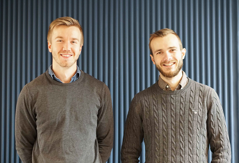 Erik Skogetun and Jonathan Rintala in front of a blue wall
