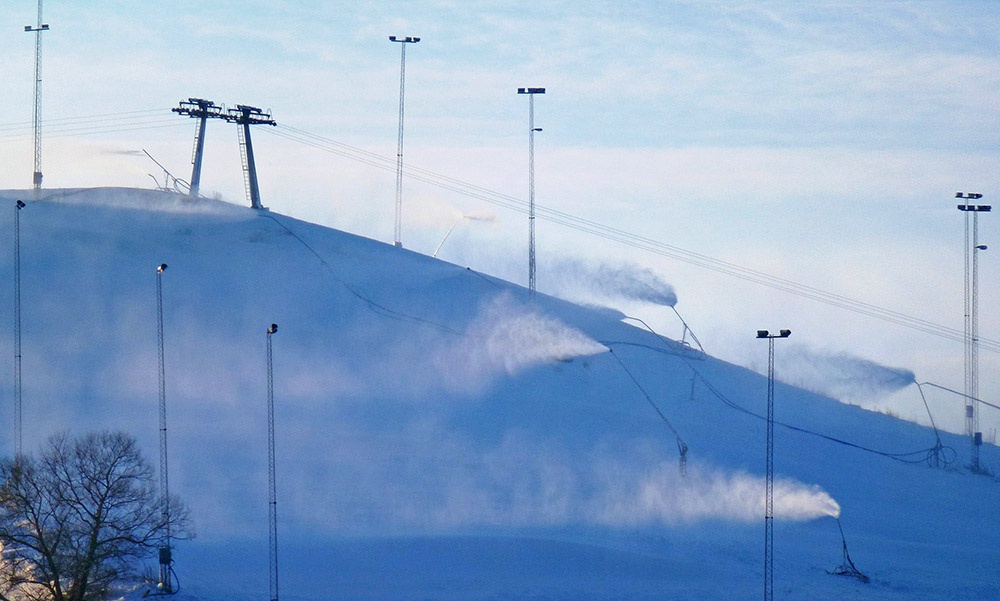 Bild föreställer Hammarbybacken med snökanoner som sprider snö