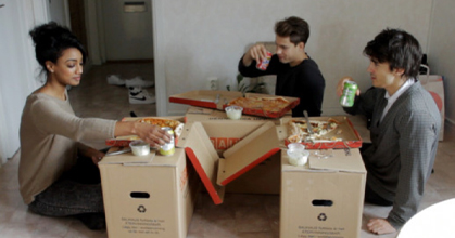 Studenter som äter flyttpizza på golvet