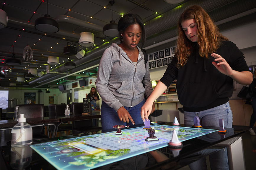 Sabrin och Lina från Akallaskolan spelar ett laserspel i en av salarna på KTH:s campus i Kista. 