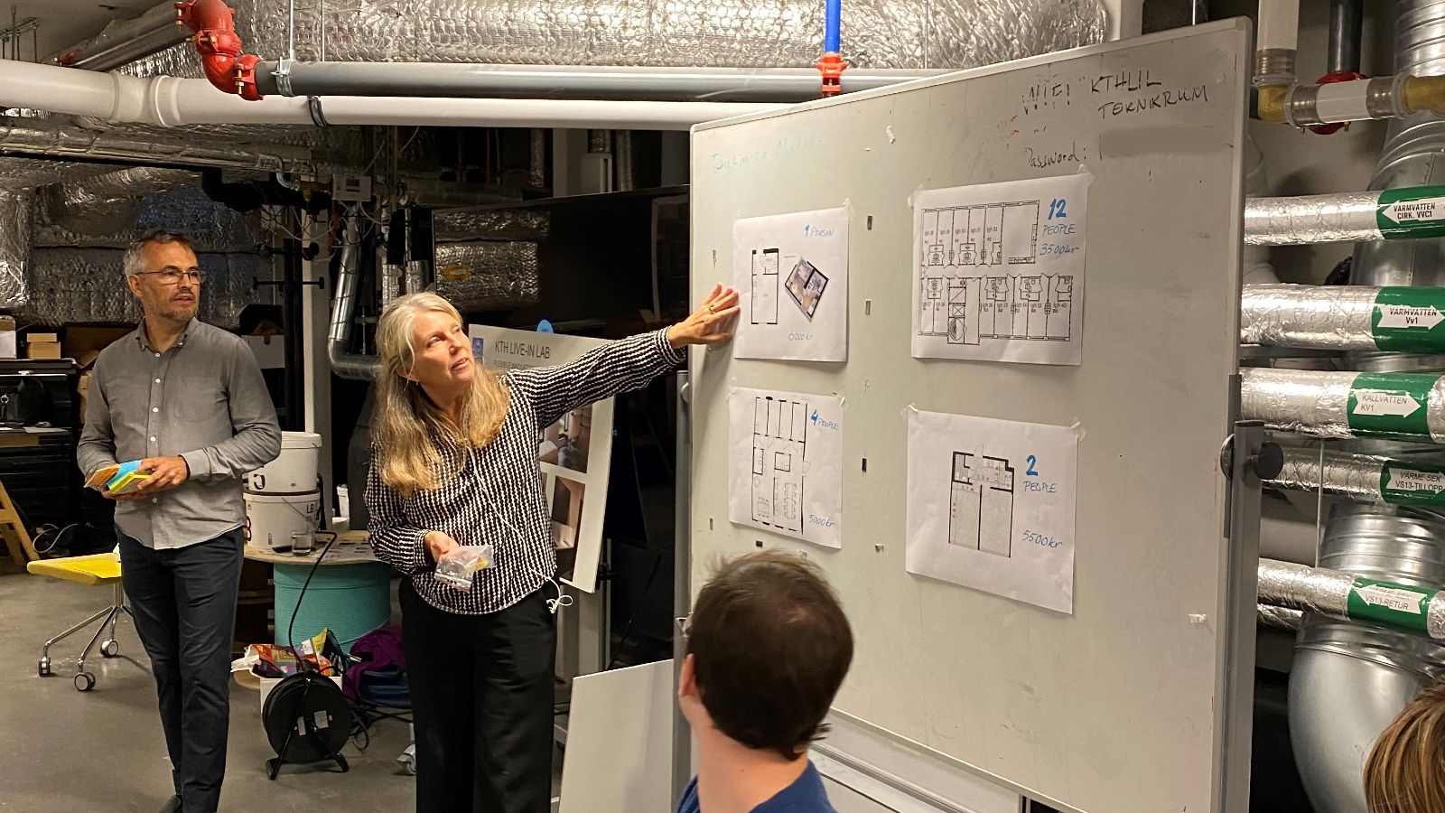 Sara Ilstedt och Martin Sjöman diskuterar planritningar och hyror i källaren på KTH Live-In Lab.