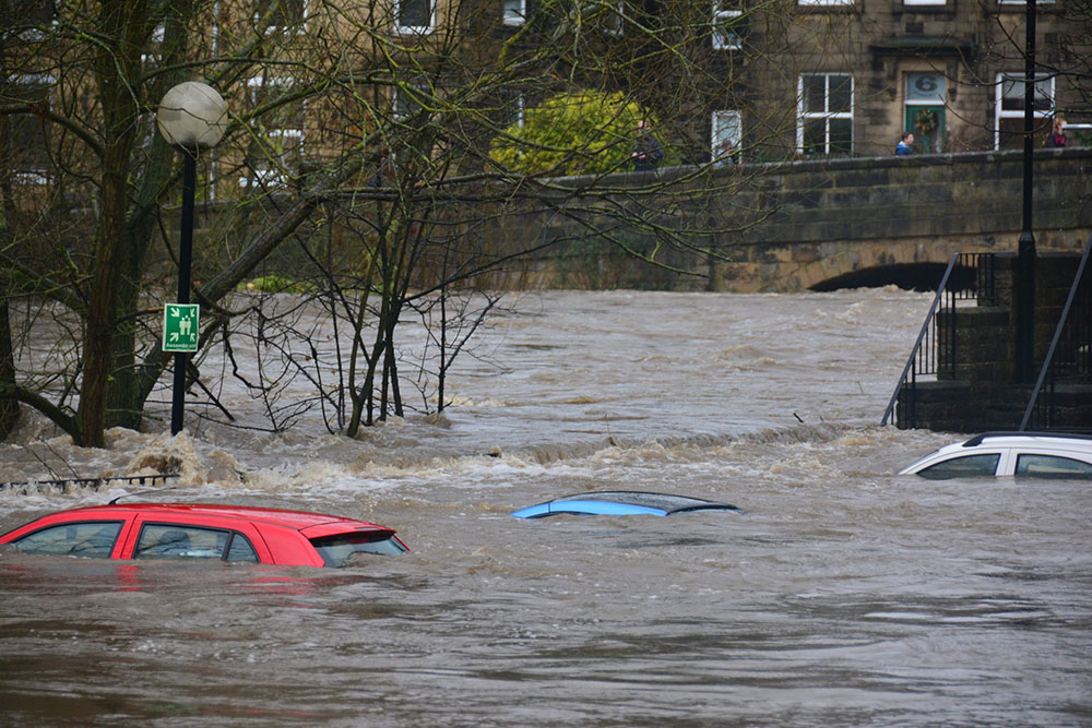 flera bilar som står under vatten vid en översvämning