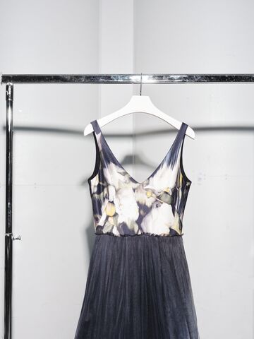 A black and beige dress hanging from a rack.