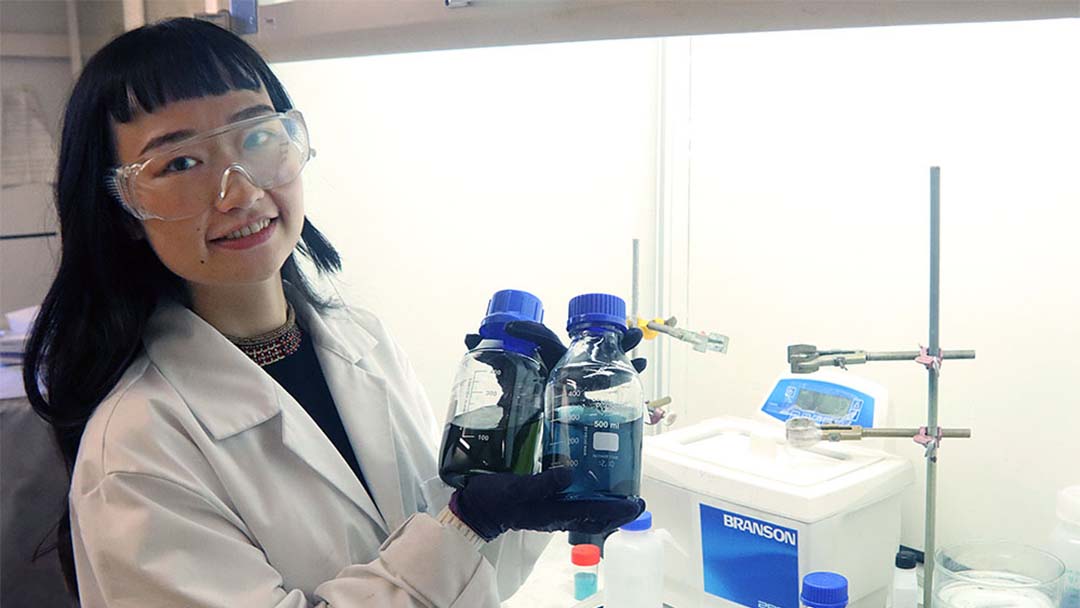 Forskaren Xiong Xiao framför dragskåp i labb.