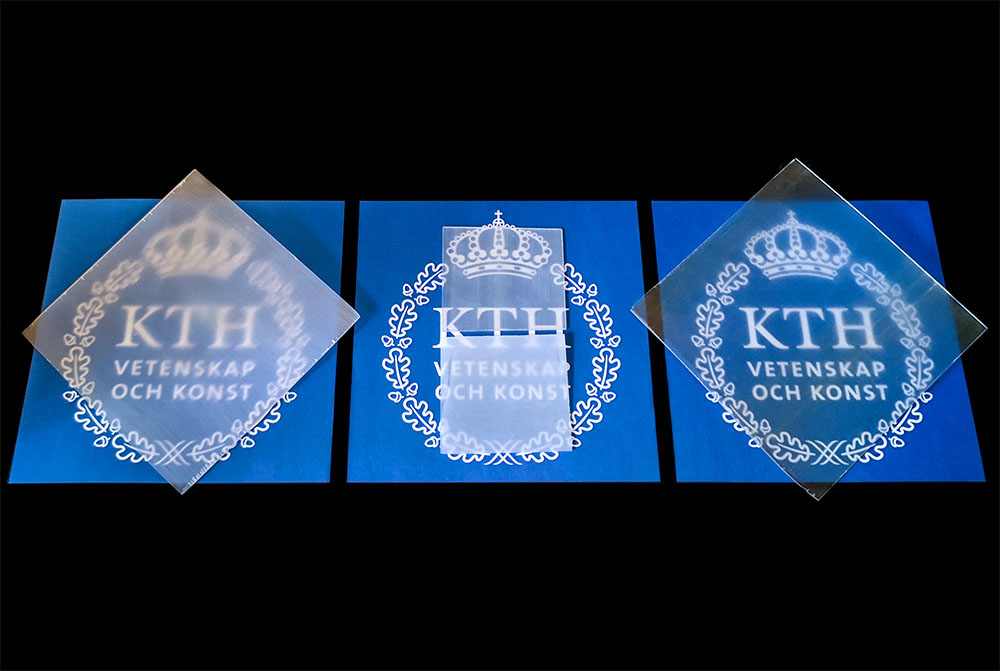 Tre olika varianter av KTH:s transparenta trä. De ligger ovanpå blå lappar med KTH:s logotyp.