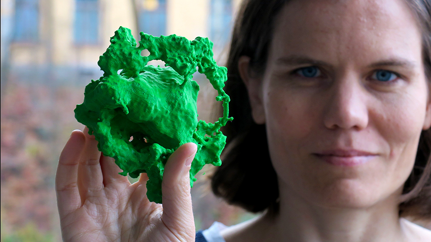 Josefin Larsson holds a green blob, a 3d printout of a supernova explosion