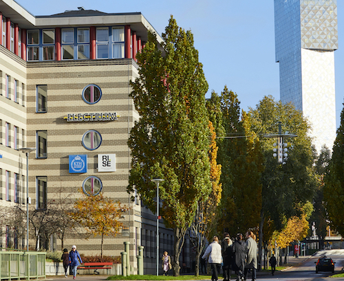 Photo: Beige coloured facade with KTH logo on, Kista tower in the background.
