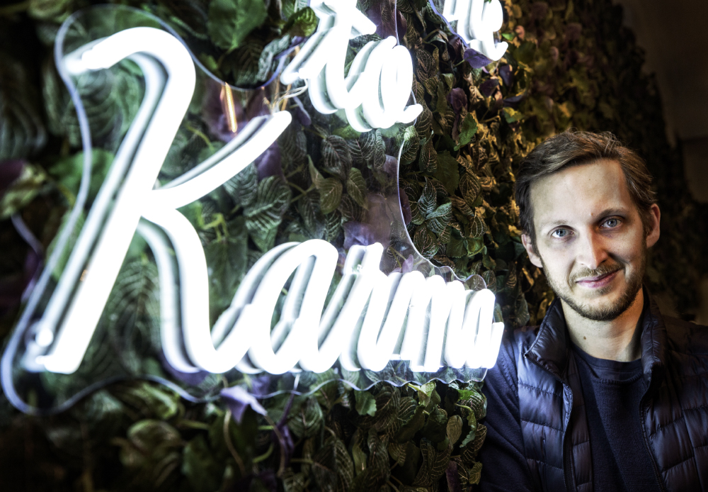 Bild på Ludvig Berling framför en Karma-logotyp på företagets kontor.