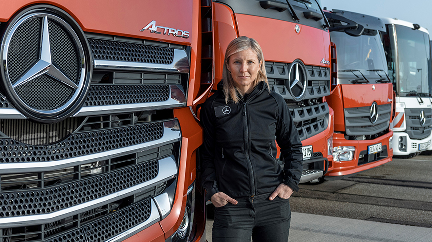 Karin Rådström standing in front of red trucks 