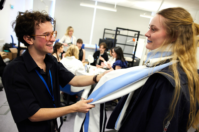 Stylist Carlos Seger corrects Ellen Olsson´s scarf.