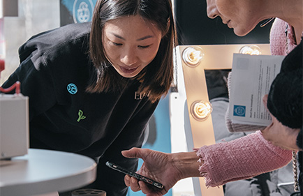 Selah Li visar KTH-startupen Ellures läppstiftsprinter för en kvinna