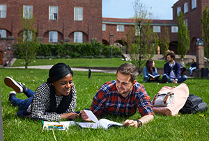 Two students studying with books outside
