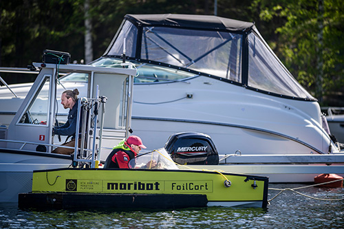 Three leisure boats moored at a jetty. In two of the boats there is a driver.