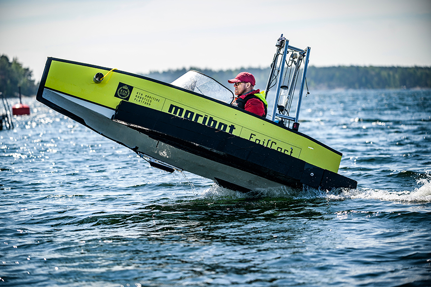 A test model of a recreational boat is performed by a person in a marine environment.