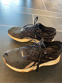 A pair of worn-out black sneakers 