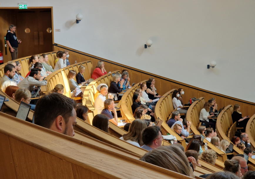Publik i gradängsal som lyssnar på en av de gemnsamma sessionerna