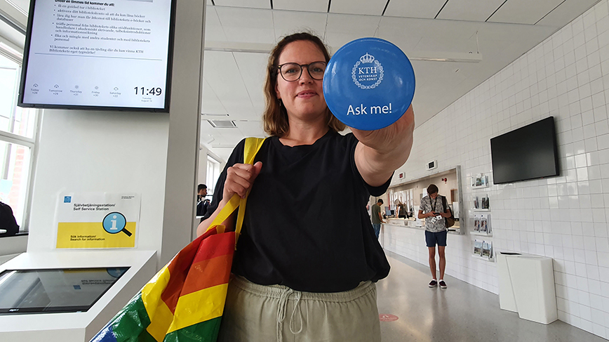 woman shows a button that reads: "Ask me about KTH"