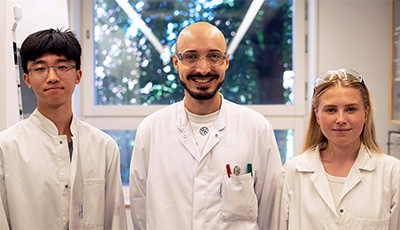 Researcher and students in lab coats. 