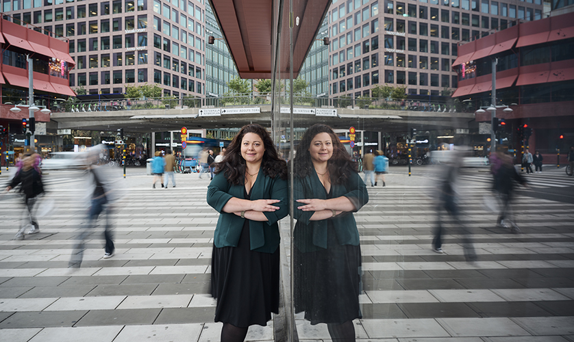 Claudia Olsson outside in the city with a mirror image on house facade