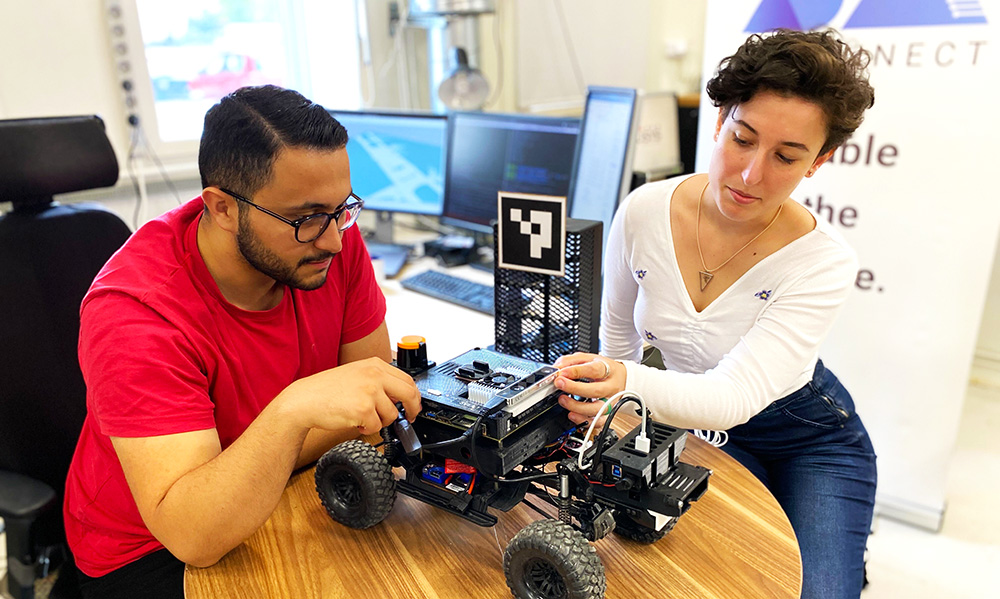 Mustafa Al-Janabi and Elisa Bin working with a radio-controlled car at a table.