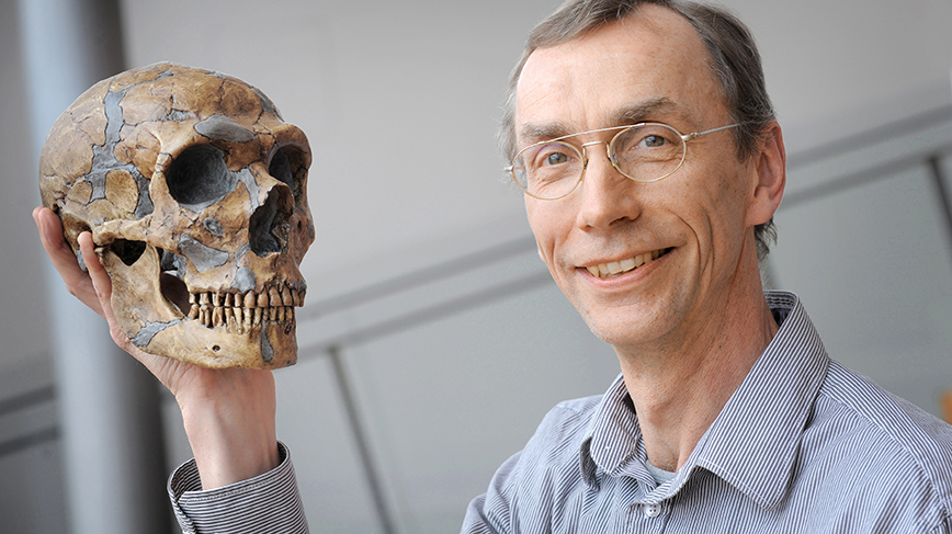 man holding skull in hand, smiling