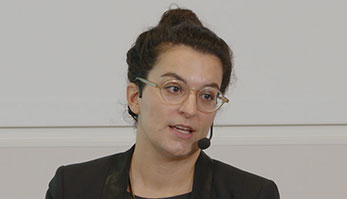 En kvinna med glasögon och mörkt uppsatt hår.