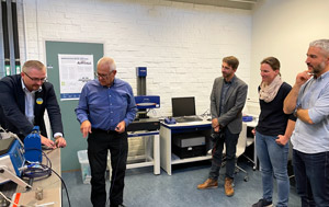 People in lab looking at metrology instrument.