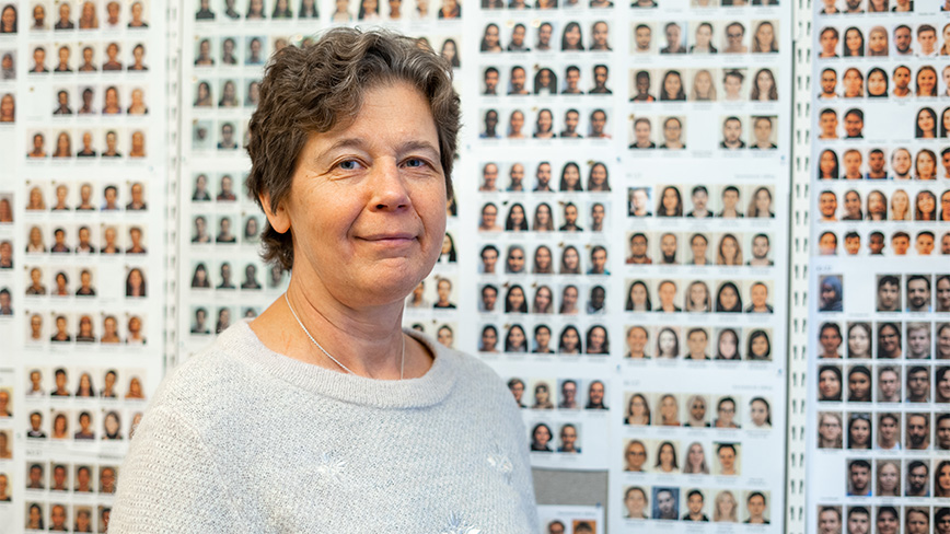 Woman in front of wall with pictures. 