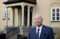 President Anders Söderholm in front of the entry of the University administration building.