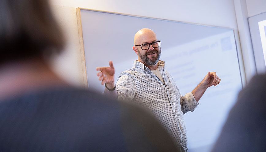 A man with a white shirt, a beard and glasses presenting. Photo: Mikael Sjöberg