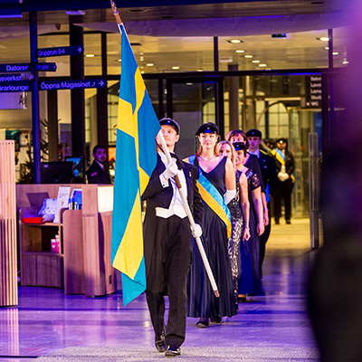 People marching in and the one at the front is holding a Swedish flag.