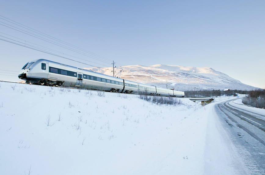 Tåg på järnväg i vintermiljö.