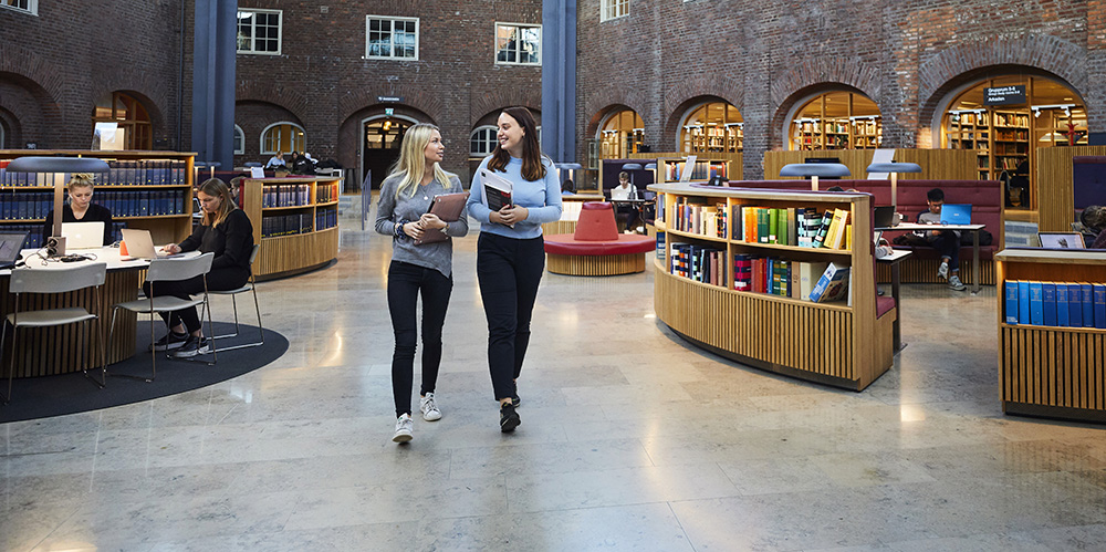 Two persons walking in the library hall.