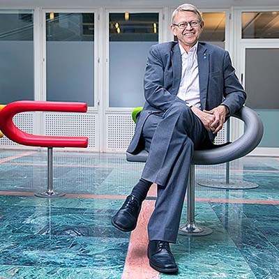 Man på en stol blickar in i kameran. 